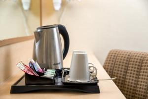 - une cafetière et une bougie sur un plateau sur une table dans l'établissement Tavistock Hotel, à Londres