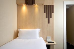 a bedroom with a bed and a phone on a table at Tavistock Hotel in London