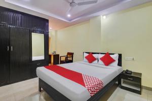 - une chambre avec un grand lit et des oreillers rouges dans l'établissement OYO Flagship 13636 Hotel Srinika Grand NEAR Shamshabad Airport, à Shamshabad