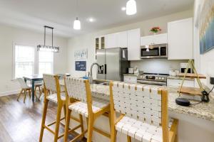 Una cocina con gabinetes blancos y una mesa con sillas. en Chic Thomasville Home Walk to Downtown!, en Thomasville