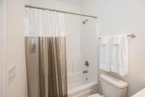 Un baño con cortina de ducha y un inodoro. en Chic Thomasville Home Walk to Downtown!, en Thomasville 22 fotos más