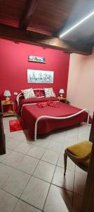 a bedroom with a large bed with a red wall at La casetta di nonna Sesa in Viterbo