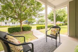 un porche con 2 sillas y una mesa en Chic Thomasville Home Walk to Downtown!, en Thomasville