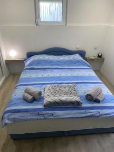 Una cama con sábanas azules y dos almohadas. en Iskra DDUR, en Gornji Milanovac