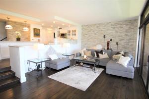 a living room with a couch and chairs and a kitchen at Kaanapali Royal Golf Retreat in Lahaina