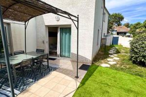 eine Terrasse mit einem Tisch und Stühlen in einem Haus in der Unterkunft Appart independent garden Pool & Spa in Sussargues