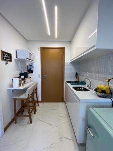 a kitchen with a counter and a sink and a door at Vista mar no costa azul in Salvador