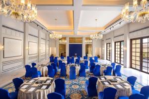 a ballroom with tables and chairs and chandeliers at Radisson Blu Resort Kumbhalgarh in Kumbhalgarh