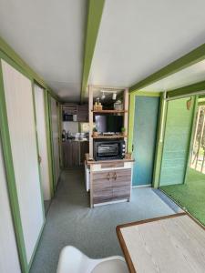 a room with green walls and a room with a microwave at Chalet in Petreto-Bicchisano