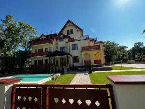 een groot huis met een zwembad ervoor bij Apartman Katarina in Palić