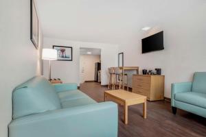 sala de estar con 2 sofás azules y TV en Chateau Beachfront Resort - BW Signature Collection, en Panama City Beach