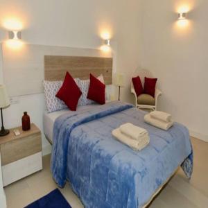 a bedroom with a large blue bed with red pillows at Felmin in Portals Nous