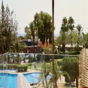 a resort with a swimming pool and palm trees at Felmin in Portals Nous