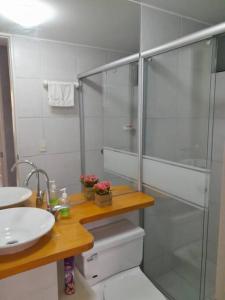 y baño con ducha acristalada y lavamanos. en Departamento El Polo, cerca a Embajada USA, en Lima