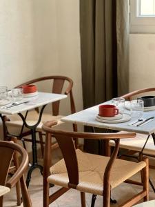 two tables and chairs with red cups on them at Hôtel des Beaux Arts in Paris