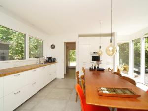 a kitchen with white cabinets and a wooden table at Charming Retreat by Water - By Traum Ferienwohnungen in Nykøbing Sjælland