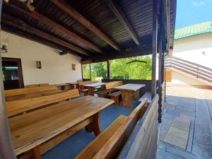 una fila de bancos de madera en un restaurante con ventanas en Bed & Breakfast Helena, en Grabovac