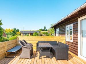 un patio con mesa y sillas en una terraza de madera en Holiday home Nordborg XXVI, en Nordborg