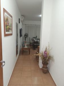 un pasillo que conduce a una sala de estar con paredes blancas en Casa Giovanini II en Puerto Iguazú