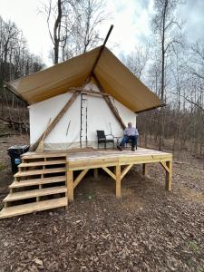 a man sitting in a tent in the woods at Growing Faith Farms in Moravian Falls