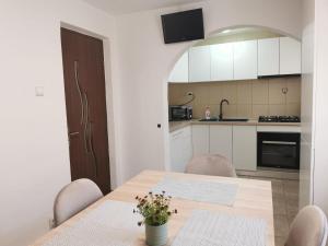 a kitchen with a wooden table with chairs and a dining room at Lovely Apartment With Courtyard in Mangalia