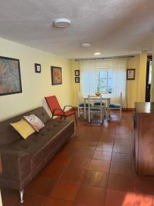 ein Wohnzimmer mit einem Sofa und einem Tisch in der Unterkunft casa amplia y económica in Villa de Leyva