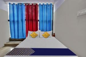 Cama en habitación con cortinas coloridas en SPOT ON Canton Lodging And Boarding, en Bangalore
