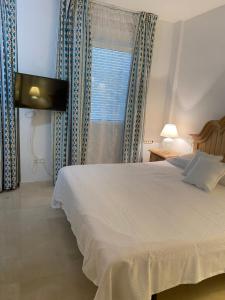 a bedroom with a white bed and a window at Casa del Mar in Zahara de los Atunes