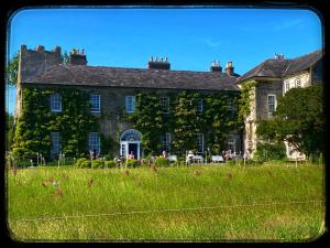 ein großes Gebäude mit einem Grasfeld davor in der Unterkunft Sanctuary Lodge in Cork