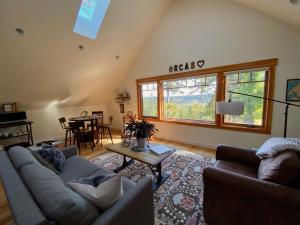 a living room with two couches and a table at Madrona Suite in Eastsound