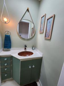 uma casa de banho com um lavatório e um espelho em Charmoso apartamento perto da praia em Vitória