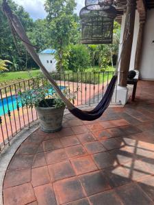 a hammock on a porch with a pool at Casa vacacional en escuintla in Guatemala