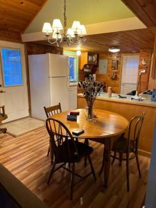 a kitchen with a table and chairs and a refrigerator at Country Cottage in Penn Yan