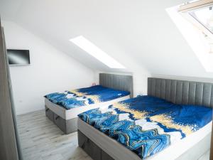 two twin beds in a room with a window at Apartamenty MARINA Puck in Puck