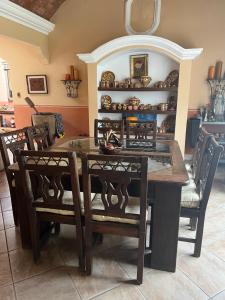 a dining room with a wooden table and chairs at Casa vacacional en escuintla in Guatemala