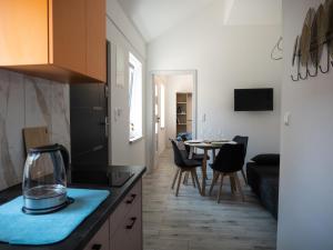 a kitchen and living room with a table and chairs at Apartamenty MARINA Puck in Puck