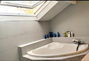 a bath tub in a bathroom with a window at La Maison bleue in Varzy +38 photos