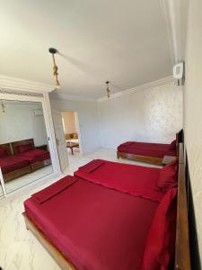 a bedroom with two beds and a mirror at Seaside Guest House in Ghār al Milḩ