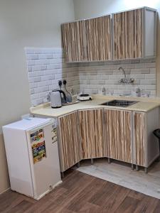 a kitchen with wooden cabinets and a refrigerator at استوديو ريفي تنومه in Tanomah
