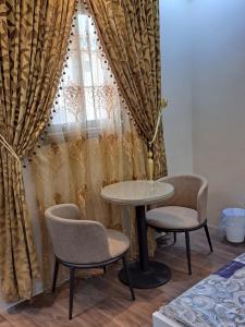 a table and two chairs in front of a window at استوديو ريفي تنومه in Tanomah
