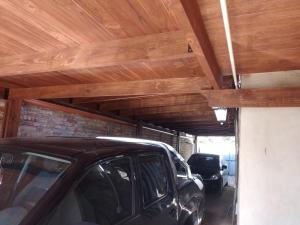 un coche aparcado en un garaje con techo de madera en Descanso Los Alamos en Plottier