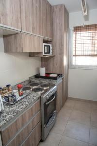 cocina con armarios de madera y horno con fogones en my place in MDZ en Godoy Cruz