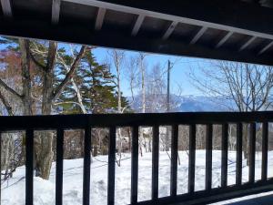 einen Balkon mit Blick auf den Schnee in der Unterkunft Robin's Lodge in Iiyama