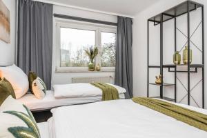 una camera con due letti e una finestra di Cityflat Balcony - WIFI, SmartTV, full Kitchen, Bathtub - Pottbude a Essen