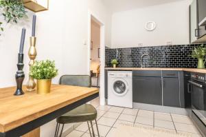 una cucina con tavolo e lavatrice di Cityflat Balcony - WIFI, SmartTV, full Kitchen, Bathtub - Pottbude a Essen