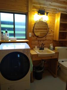 a bathroom with a sink and a tv in a room at Robin's Lodge in Iiyama