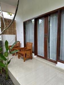 a porch with two chairs and a bench on it at Santai Retreat in Kuta Lombok