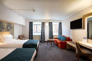 Habitación de hotel con cama y sofá en Bedford Hotel, en Londres