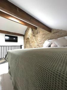 a bed in a room with a stone wall at Farsley Cottage in Farsley