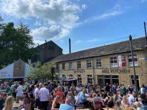 a crowd of people sitting outside of a building at Farsley Cottage in Farsley